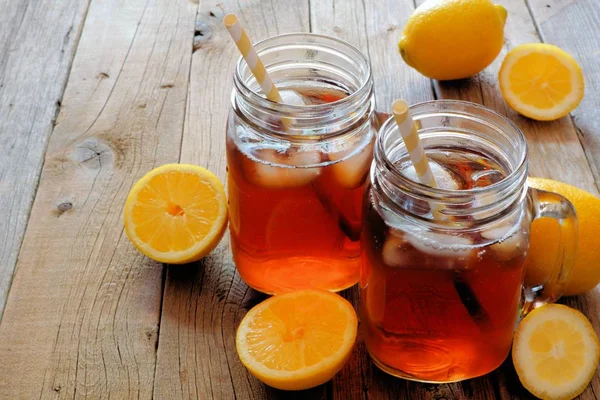 Dvě sklenice mason citronu ledový čaj na rustikální dřevo — Stock fotografie