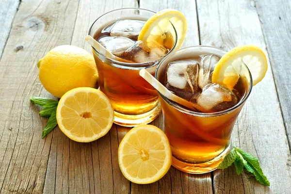 Two glasses of iced tea with lemon slices on rustic wood Royalty Free Stock Images