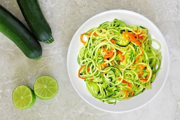 Plato de fideos de calabacín saludable sobre fondo de mármol blanco — Foto de Stock