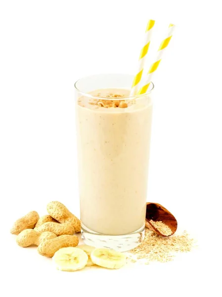 Smoothie de aveia de banana de manteiga de amendoim com ingredientes espalhados sobre branco — Fotografia de Stock