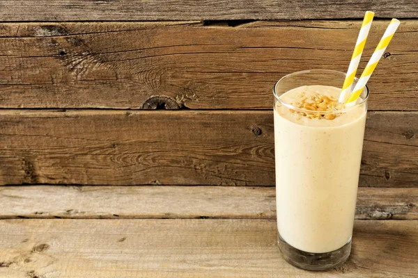 Mantequilla de cacahuete plátano avena desayuno batido contra la madera rústica — Foto de Stock