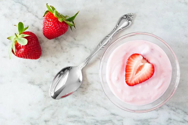 Yogurt alla fragola con bacche, vista sopraelevata su marmo bianco — Foto Stock