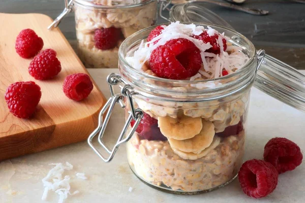 Overnight oats with raspberries and shredded coconut in a jar