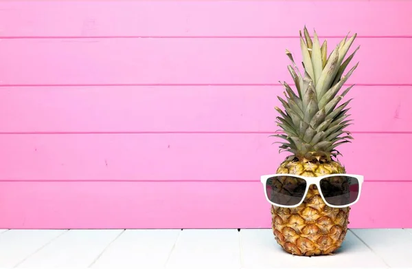 Ananas hipster avec lunettes de soleil contre le bois rose — Photo