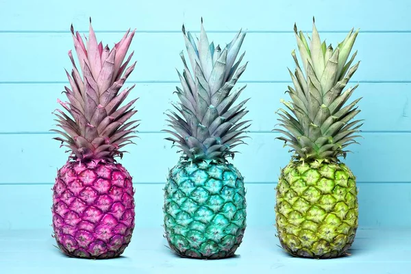 Ananas colorés sur fond de bois bleu pastel — Photo