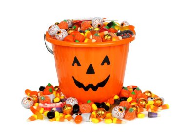 Halloween Jack o Lantern pail with pile of candy over white  clipart