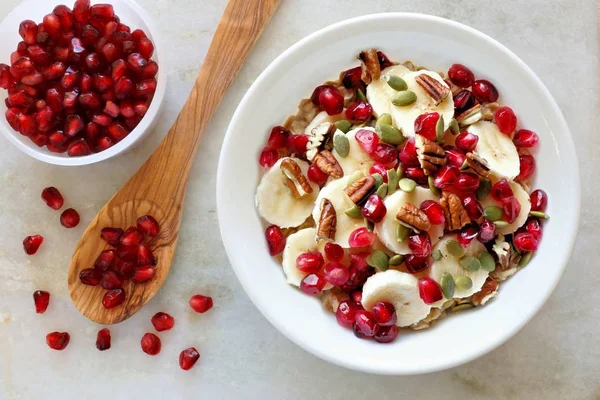 Breakfast oatmeal with pomegranates overhead on marble — Stock Photo, Image