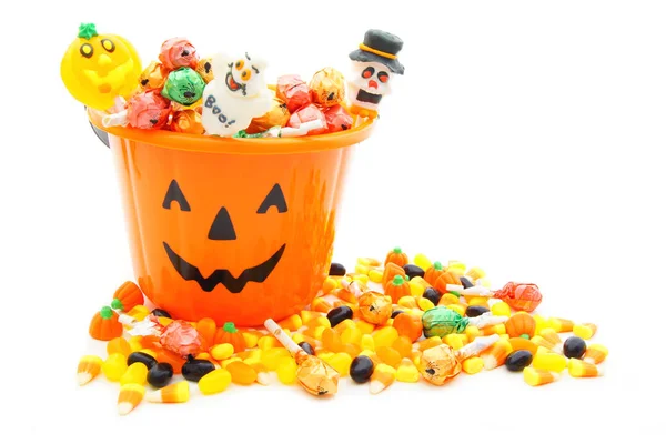 Cubo de caramelo Jack o Lantern con una pila de caramelos de Halloween — Foto de Stock