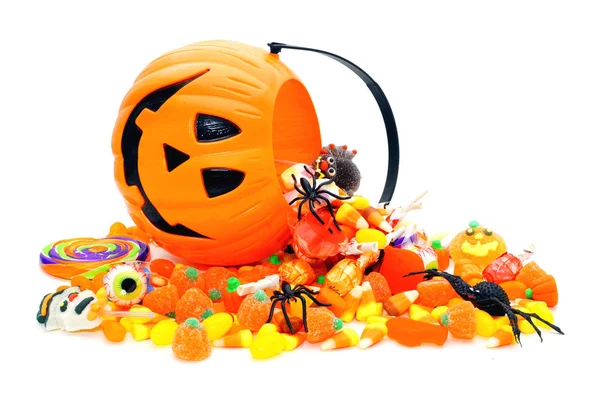 Halloween-Bonbons verschüttet von einem Jack o Laternenhalter über weiß — Stockfoto