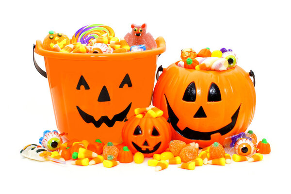 Halloween Jack o Lantern candy holders and pile of candies over white