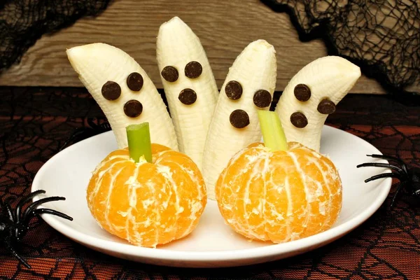 Healthy Halloween treats, banana ghosts and orange pumpkins