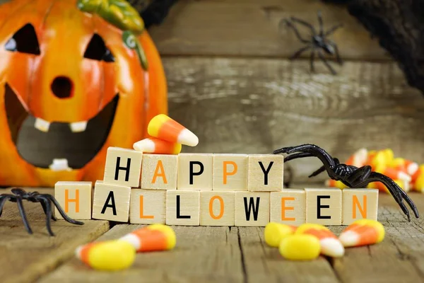 Happy Halloween wooden blocks with candy corn and decor against old wood