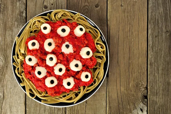 Halloween cheesy eyeball massas com molho de carne de tomate, acima vista ob madeira velha — Fotografia de Stock