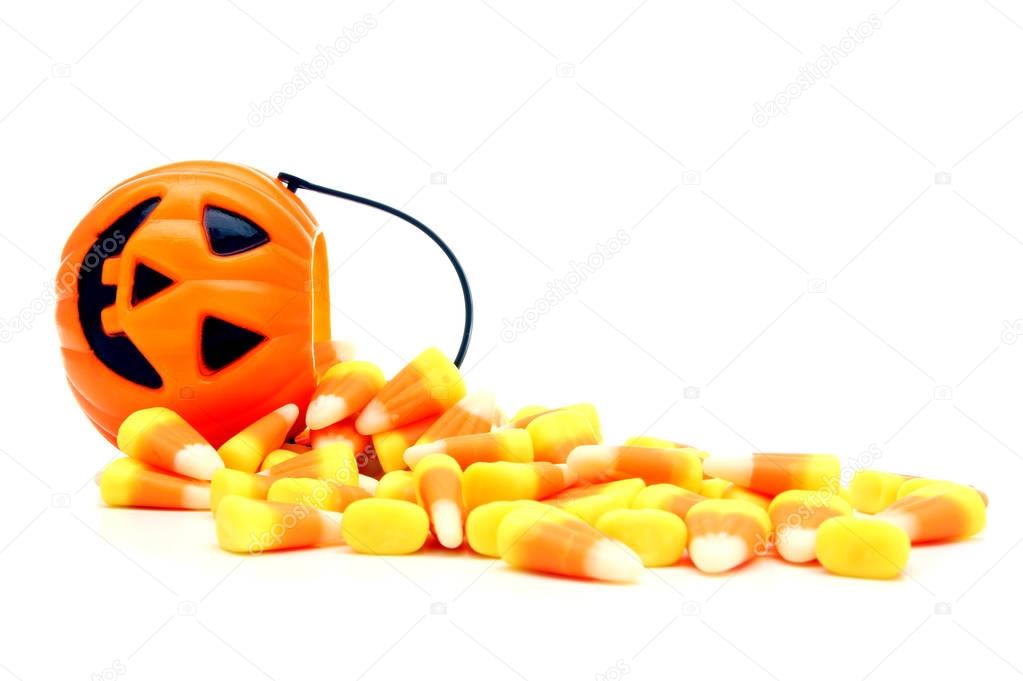 Pumpkin candy holder with spilling Halloween candy corn