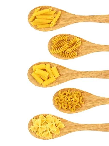 Spoons filled with various dry pasta over white — Stock Photo, Image