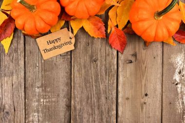 Mutlu Şükran günü etiketi ile üst kenarını kabaklar ve tahta üzerinde yapraklar
