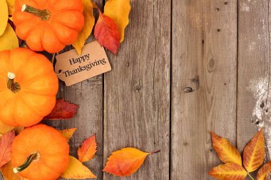 Mutlu Şükran günü etiketi ile yan sınır kabaklar ve tahta üzerinde yapraklar