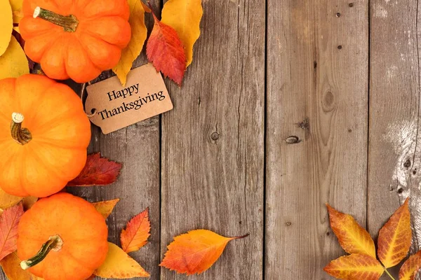 Mutlu Şükran günü etiketi ile yan sınır kabaklar ve tahta üzerinde yapraklar