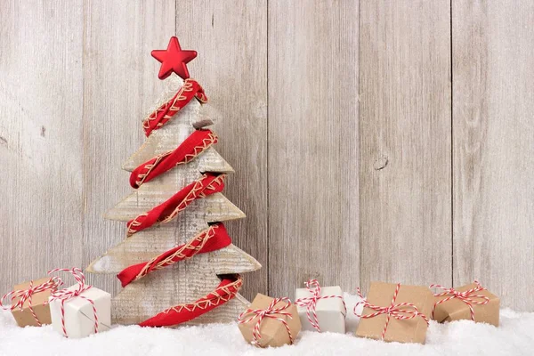 Dřevěný vánoční stromeček s červeným věnec a dary dřevo — Stock fotografie