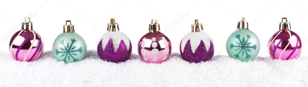 Purple, pink & turquoise Christmas baubles in snow isolated