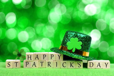 Cüce cin şapka ve yonca parlayan yeşil arka plan üzerinde mutlu St Patricks Günü ahşap bloklar