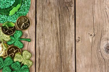 St Patricks Günü yan kenarlığını shamrocks, altın ve cin şapka rustik ahşap üzerinde