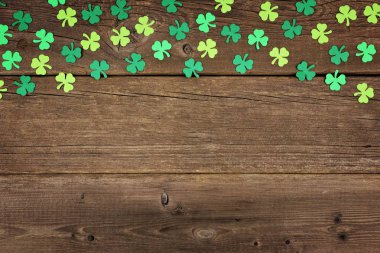 Eski bir rustik ahşap arka plan üzerinde kağıt yoncaları St Patricks Günü üst kenarlığı