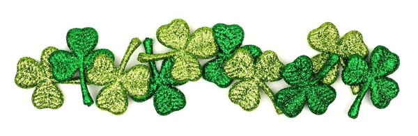 Border of St. Patricks Day shiny shamrocks over a white background
