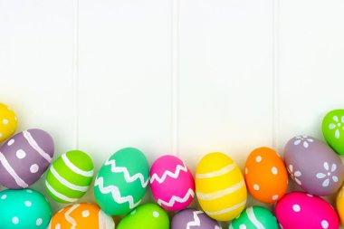 Renkli Paskalya yortusu yumurta alt kenarlık bir beyaz ahşap arka plan