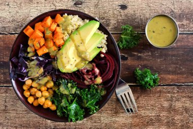 Quinoa, avokado, nohut, ahşap arka plan üzerinde sebze ile Buda kase. Sağlıklı gıda kavramı. Üstten Görünüm.