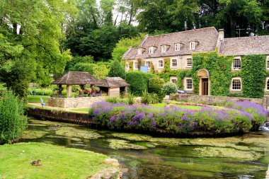 Picturesque garden in the Cotswold village of Bibury, England clipart