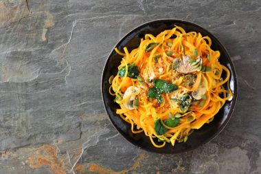 Ispanak ve kabak çekirdeği karanlık arduvaz arka planda, kavram yeme sağlıklı ile butternut squash spirilized erişte. Üstten Görünüm.