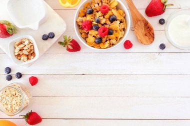 Beyaz ahşap zemin üzerinde bir köşe sınır oluşturan sağlıklı bir kahvaltı için malzemeler. Üstten Görünüm. Kopya alanı.