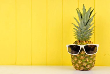 Hipster ananas sarı ahşap arka plan karşı trendy güneş gözlüğü ile. En az yaz konsepti.