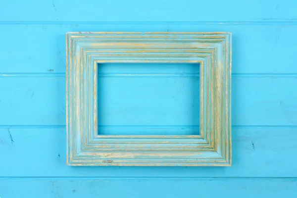 Empty rustic blue wooden frame against a blue wood background. Copy space.