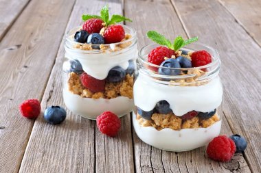 Sağlıklı yaban mersini ve ahududu gezegendeki mason kavanoz rustik ahşap arka plan üzerinde