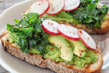 Sağlıklı avokado tost yakın çekim lahana ve turp tam tahıllı ekmek üzerinde