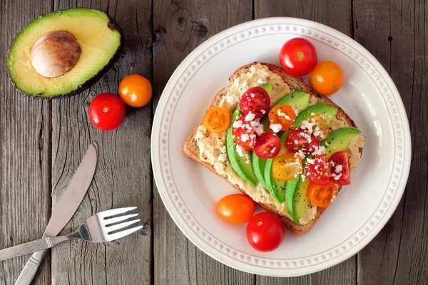 Avokádový Toast Hummus Rajčaty Štítku Nad Scénu Staré Dřevěné Pozadí — Stock fotografie