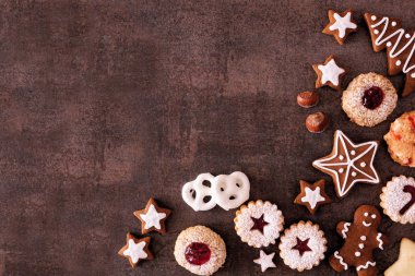 Çeşitli Noel kurabiyeleri ve tatlılar. Üzerinde fotokopi alanı olan koyu taştan bir arkaplan var. Tatil pişirme konsepti.