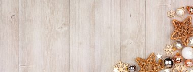 Beyaz ve altın süslemeli noel pankartı. Fotokopi alanı olan gri ahşap bir arkaplanda görünümün üstünde.