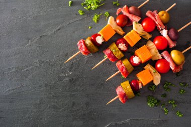 Etli, peynirli ve turşulu mezeler. Kopya alanı olan koyu bir arkaplan üzerindeki köşe kenarlığının üzerinde.