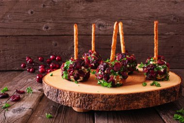 Yaban mersinli, cevizli ve otlu bayram peynir topu aperatifleri ahşap bir arka planda kırsal bir ahşap tabakta.
