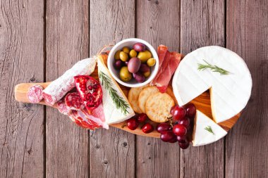 Etler, peynirler ve aperatifler servis ediliyor. Kırsal ahşap arka planda genel görünüm.