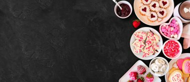 Sevgililer Günü sınır bayrağında bir sürü tatlı ve kurabiye var. Koyu taştan bir arkaplan üzerinde üst manzara. Aşk ve kalp teması. Boşluğu kopyala.