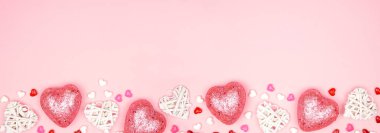 Pembe arka planda pembe ve beyaz kalp süslerinden oluşan uzun kenarlı Sevgililer Günü afişi. Boşluğu kopyala.