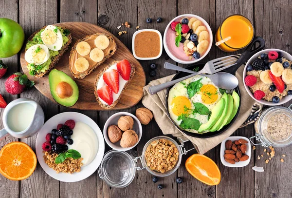 フルーツ ヨーグルト オートミール スムージー 栄養価の高いトーストと卵のフライパンで健康的な朝食テーブルシーン 木の背景の上からの眺め — ストック写真