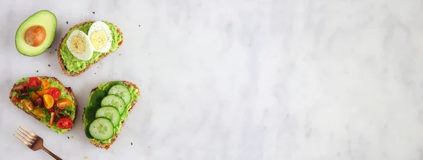 Здоровый Ассортимент Тостов Авокадо Яйцами Помидорами Огуречным Шпинатом Знамя Боковой — стоковое фото