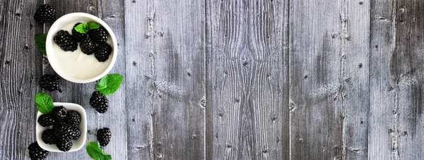 Taze böğürtlenli sağlıklı yoğurt. Kırsal ahşap arka planda yan sınırı olan üst manzara afişi. Boşluğu kopyala.