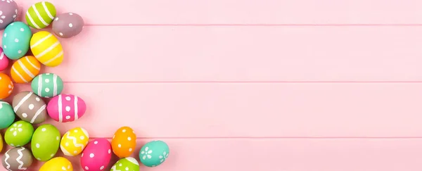 色彩艳丽的复活节横幅 上面有复活节彩蛋的边角 衬托着粉色的木头背景 具有复制空间的头顶视图 — 图库照片