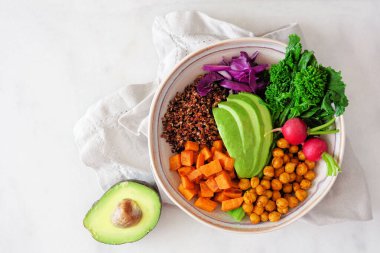 Rapini, kinoa, tatlı patates, nohut ve avokado ile sağlıklı Buda kasesi. Beyaz mermer bir arkaplan üzerinde manzara.